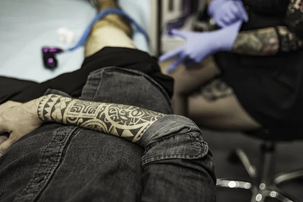 Close up tribal tattoo arm of a client in tattoo studio