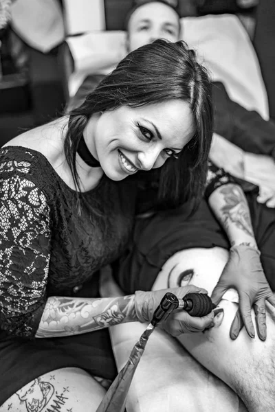 Stående kvinna tattoo artist arbetar tatuering. Hög vinkel. — Stockfoto