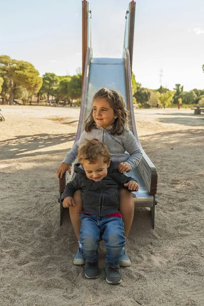 Crianças se divertindo no slide no playground — Fotografia de Stock