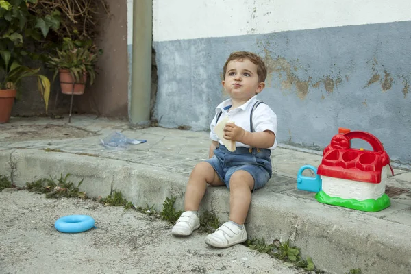 Tiro completo retrato bonito bebê menino ter um lanche sentar no sidew — Fotografia de Stock