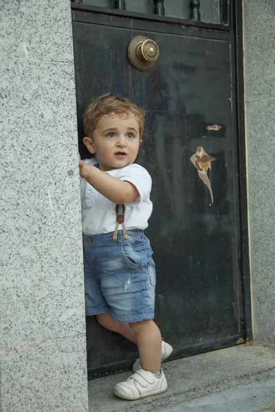 充分的镜头的肖像可爱男婴房子门边站着 — 图库照片