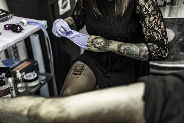 Närbild kvinna hand med latexhandske, tatuera i tatueringsstudio — Stockfoto