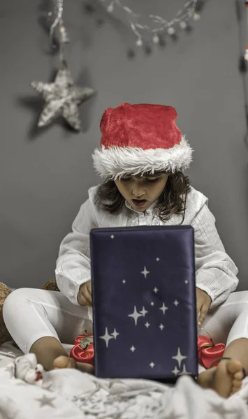 Belle fille portant le chapeau de Père Noël surpris l'ouverture d'un cadeau. Chris ! — Photo