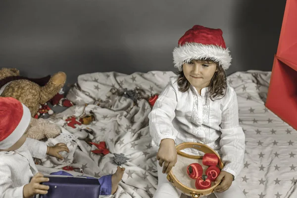 Enfants avec chapeau de Père Noël levant les yeux. Pommes rouges, tambourin et C — Photo