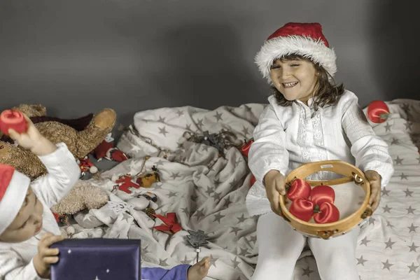 Enfants avec chapeau de Père Noël levant les yeux. Pommes rouges, tambourin et C — Photo