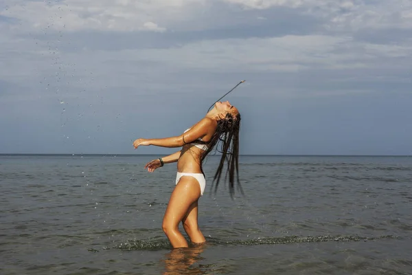 Adolescente feliz jugando con el agua en la orilla del mar del bea — Foto de Stock