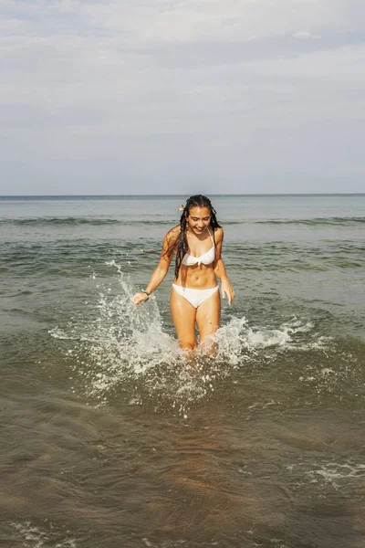 Adolescente feliz jugando con el agua en la orilla del mar del bea — Foto de Stock