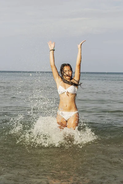 Adolescente feliz jugando con el agua en la orilla del mar del bea — Foto de Stock