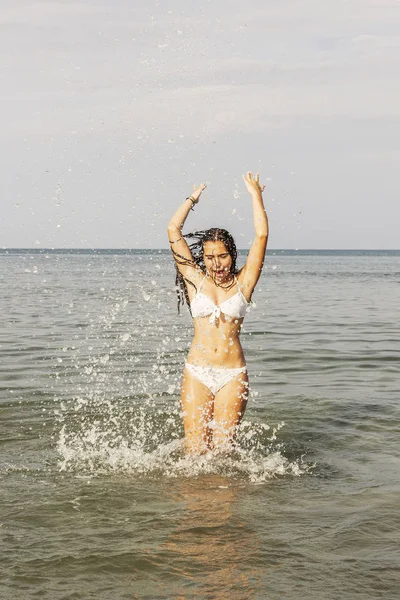 Adolescente feliz jugando con el agua en la orilla del mar del bea — Foto de Stock