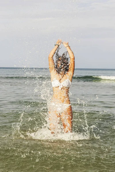 Adolescente feliz jugando con el agua en la orilla del mar del bea — Foto de Stock