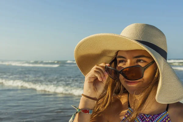 Chica en la playa con sombrero de playa de verano y gafas de sol admiri — Foto de Stock