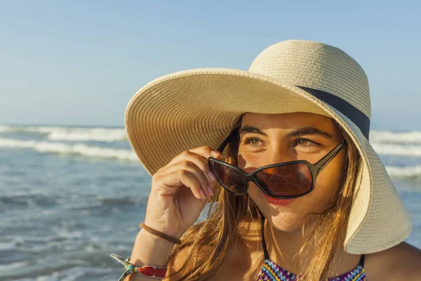 Chica en la playa con sombrero de playa de verano y gafas de sol admiri — Foto de Stock