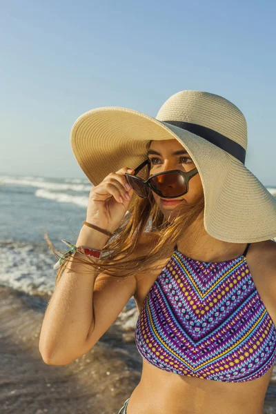 Chica en la playa con sombrero de playa de verano y gafas de sol admiri — Foto de Stock