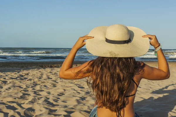 Mujer joven por detrás, con sombrero de verano y pantalones vaqueros en — Foto de Stock