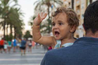 Arka görünümü adam erkek gülümseyen bir bebek tutan. Yaz plaj yer.