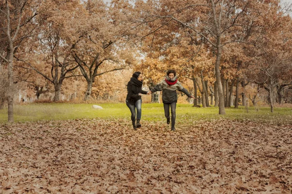 Jovens mulheres correndo no parque sobre um campo cheio de folhas. Aut. — Fotografia de Stock