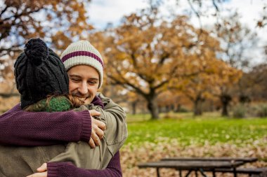 Portre genç bir çift bir sonbahar arka planda sarılma. Arkadan Görünüm