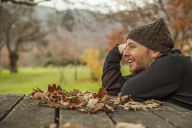 Yan yüz yakın oturan yün şapkalı adam gülümseyen portre çekim