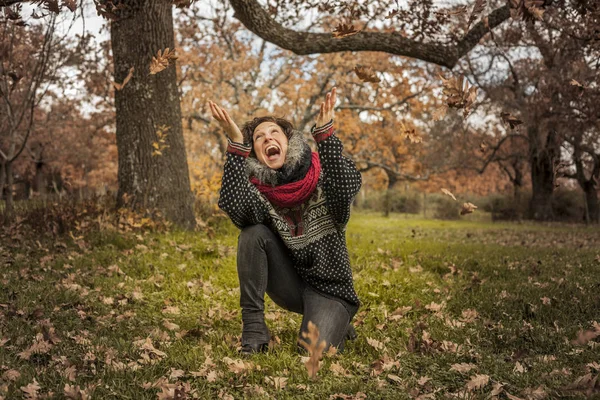 Retrato de mujer feliz divirtiéndose con hojas en otoño — Foto de Stock