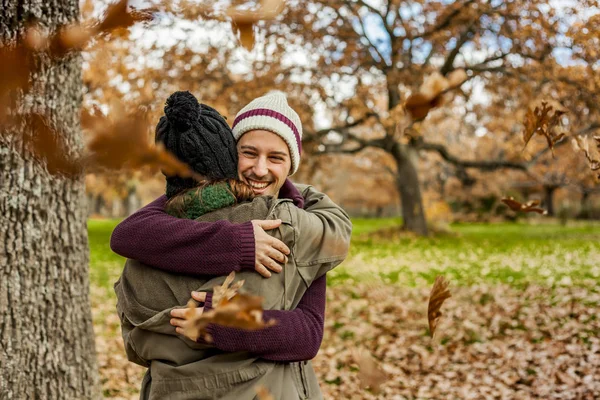 Portrait young couple hugging in a rain of leaves. Back view of — Stock Photo, Image