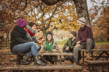 Arkadaşlar karakolda ve yaprakları bir parkta yukarı atma