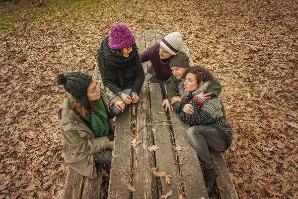 Amigos hablando en un banco en un parque en otoño — Foto de Stock