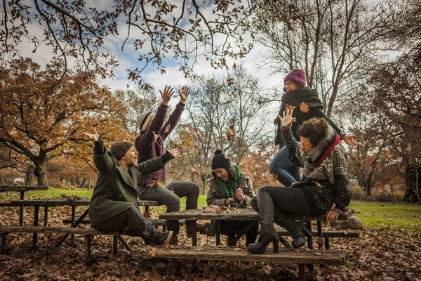 Mujer vomitando hojas en el parque con amigos — Foto de Stock