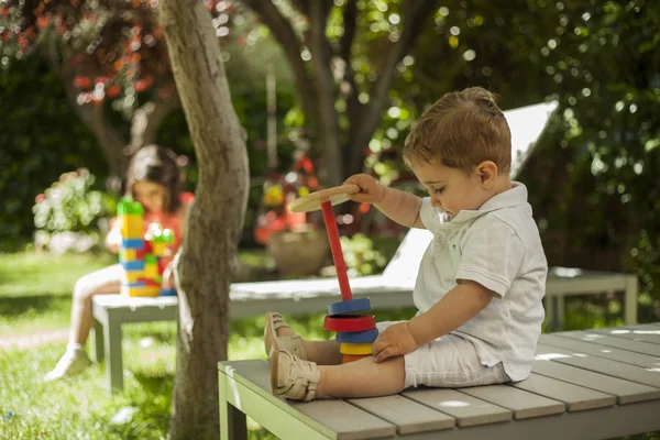 Děti si hrají s hračkami stavby v zahradě. Jaro — Stock fotografie