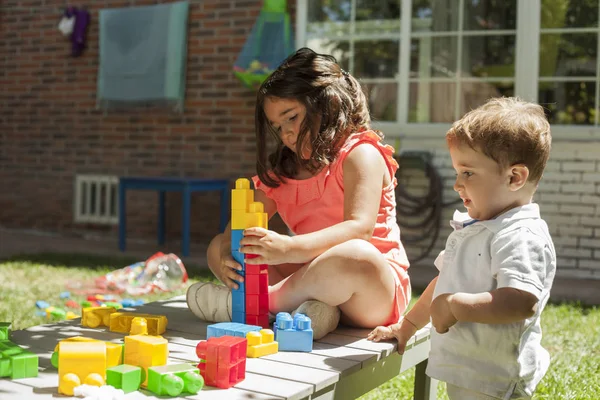 Děti si hrají s hračkami stavby v zahradě. Jaro — Stock fotografie