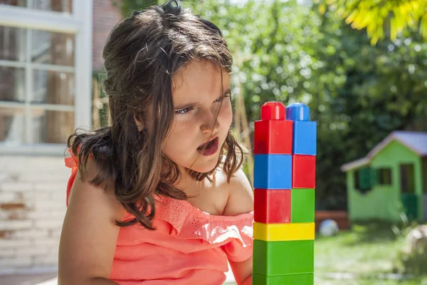 Stående flicka byggnad med plast konstruktion leksaker i gar — Stockfoto