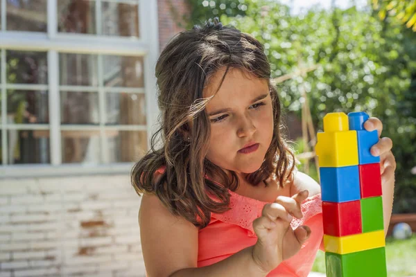 Zblízka portrétní dívka si hraje s plastová stavebnice v — Stock fotografie