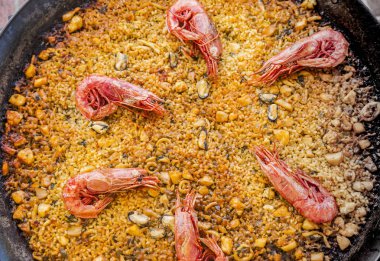 Büyük bir tavada İspanyolca lezzetli paella paella aradı. Pirinç ile s