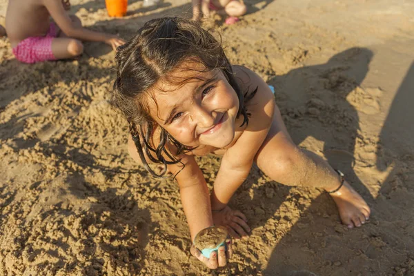 Ragazza che gioca con la sabbia sulla spiaggia. Summert — Foto Stock