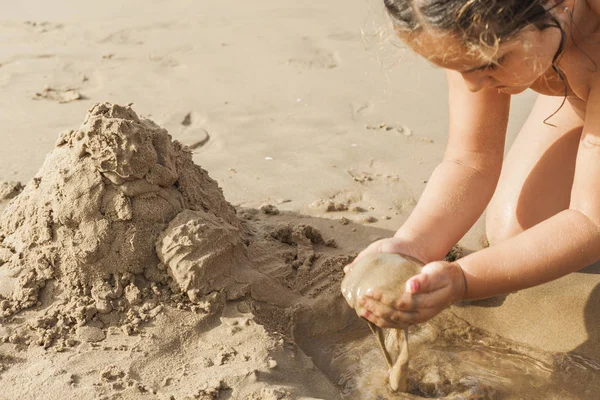 Ragazza che gioca con la sabbia sulla spiaggia. Summert — Foto Stock