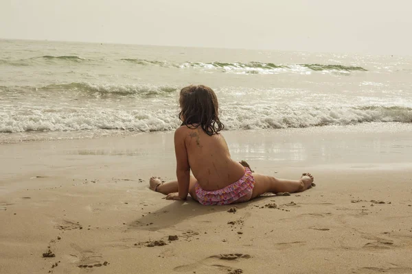 Chica vista trasera con traje de baño rosa en la orilla del mar de la playa — Foto de Stock
