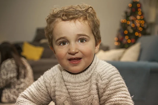Feche-se retrato sorrindo menino na véspera de Natal. Luzes orna — Fotografia de Stock