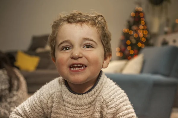 Feche-se retrato sorrindo menino na véspera de Natal. Luzes orna — Fotografia de Stock