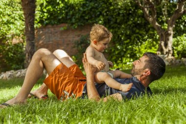 Erkek bebek ve arka bahçe köpek oynamaya baba. Yaz Zamanı