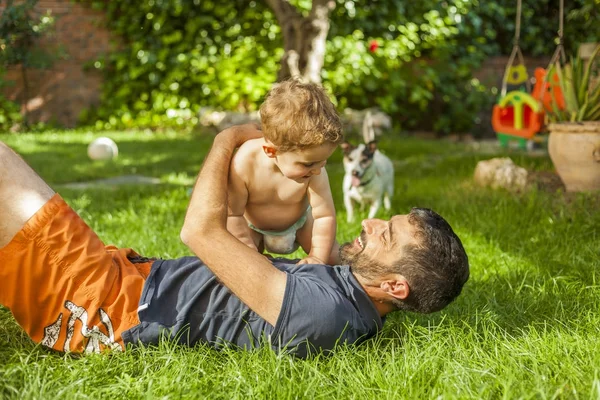 Erkek bebek ve arka bahçe köpek oynamaya baba. Yaz Zamanı