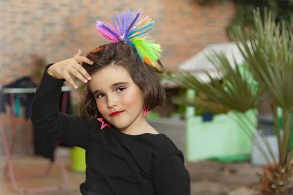 Portrait child dressed as a rocker with star earings and rainbow