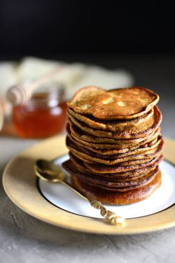Çikolatalı krep tabakta bal ile yığılmış