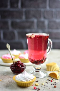 Bir bardak tatlı - tartlets ve kiraz reçeli bir masada kırmızı meyve çayı