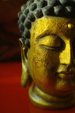 Kopya alanı koyu kırmızı zemin üzerine altın Buddha sakin yüz