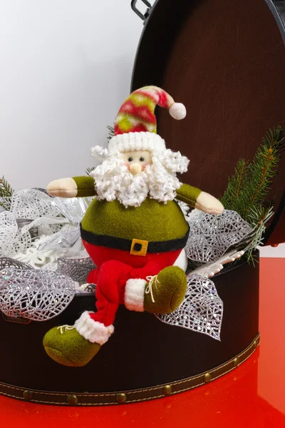 Santa Claus sits on vintage brouwn coffer with white christmas t — Stock Photo, Image