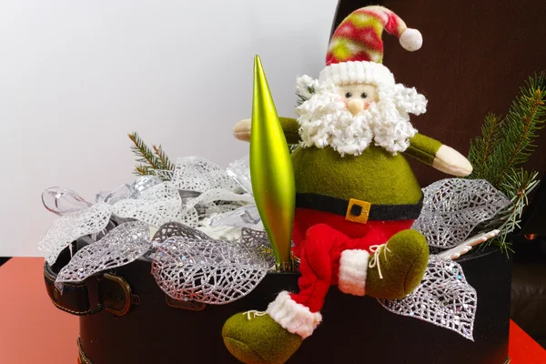 Santa Claus sits on vintage brouwn coffer with white christmas t — Stock Photo, Image