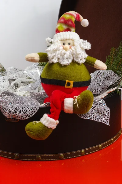 Santa Claus sits on vintage brown coffer with white christmas decoration — Stock Photo, Image