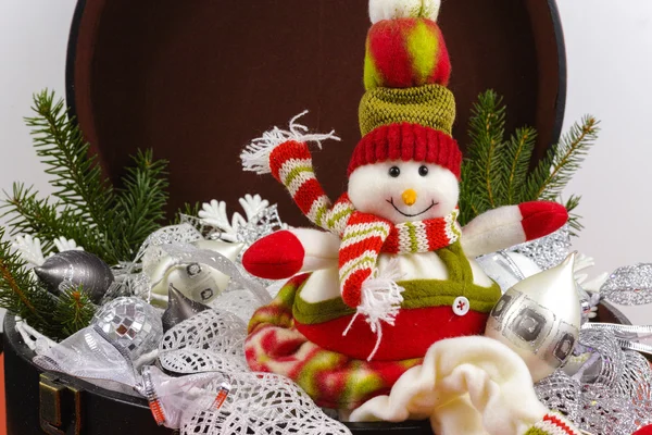 Funny snowman sits on vintage brown coffer with white  Christmas — Stock Photo, Image