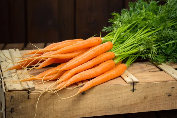 Ahşap kutu üzerinde taze turuncu havuç demet