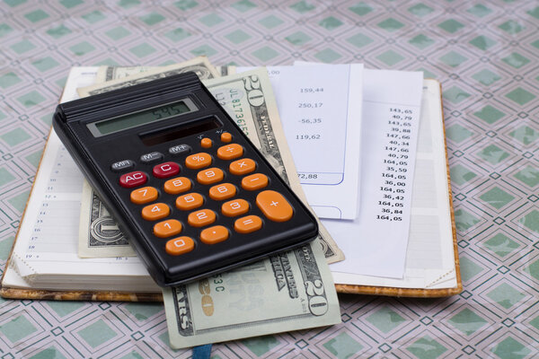 Коммунальные или ипотечные счета, калькулятор и доллары США - финансовая концепция

