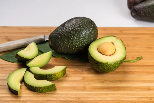 Avocado fresco verde con foglie — Foto Stock